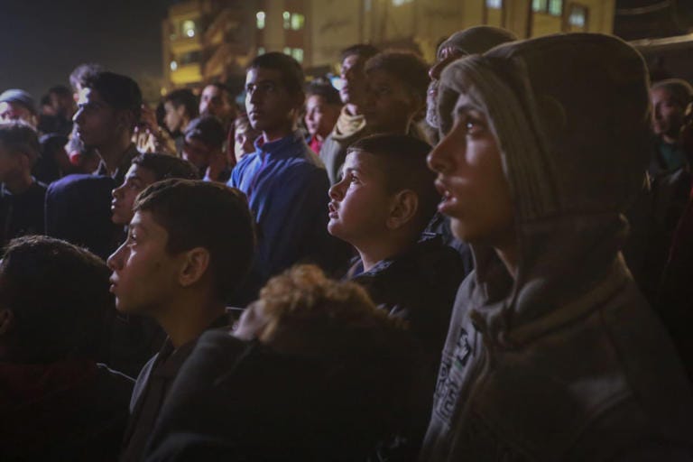 Palestinians await the announcement on TV of a cease-fire deal between Hamas and Israel in Gaza.