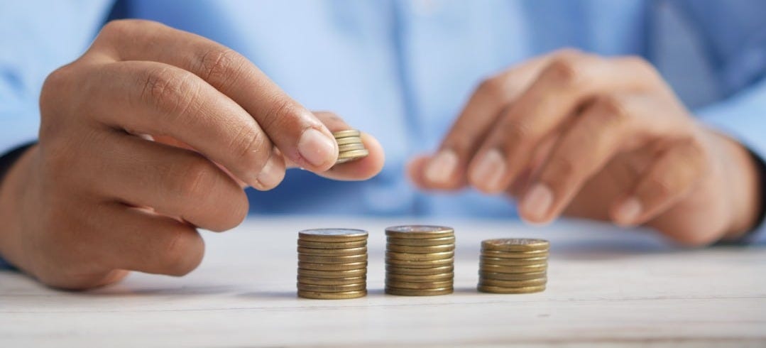 a person stacking coins on top of a table