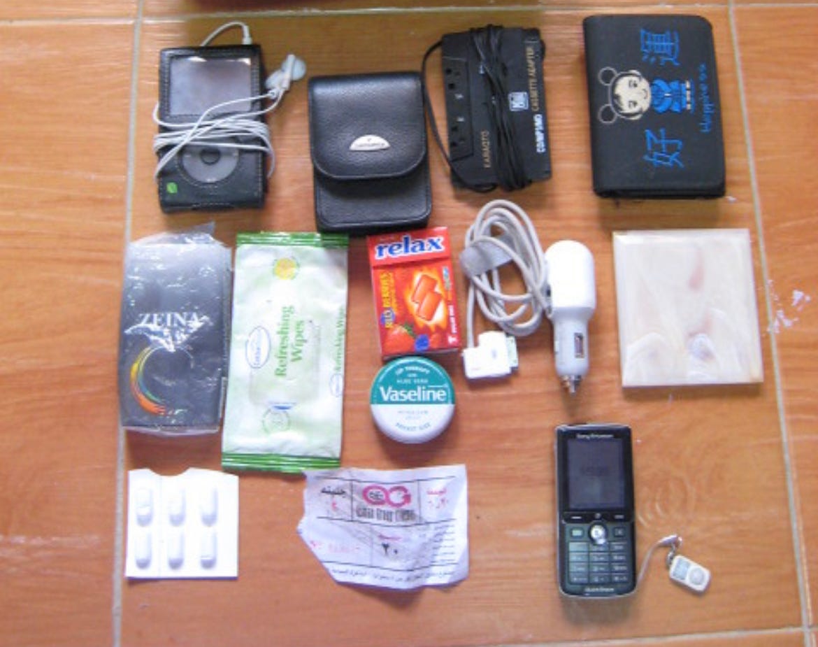 A "What's in my Bag" from the 200s showing an sony errikson candybar phone, and ipod, and some random bits and bobs
