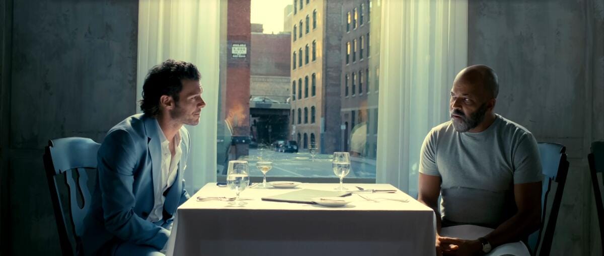 Movie still from American Fiction. Two men sit at a restaurant table.