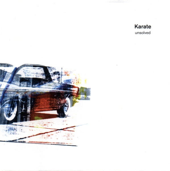 The cover for Karate’s UNSOLVED album. It is mostly pure white. On the left side is a heavily processed photo of an old-style car with white wall tires, that has been colored in various shades of blue red and yellow.