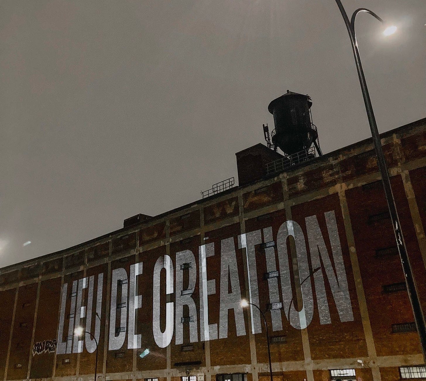 Projection sur l’entrepôt Van Horne, la nuit. On peut y lire: « LIEU DE CRÉATION »