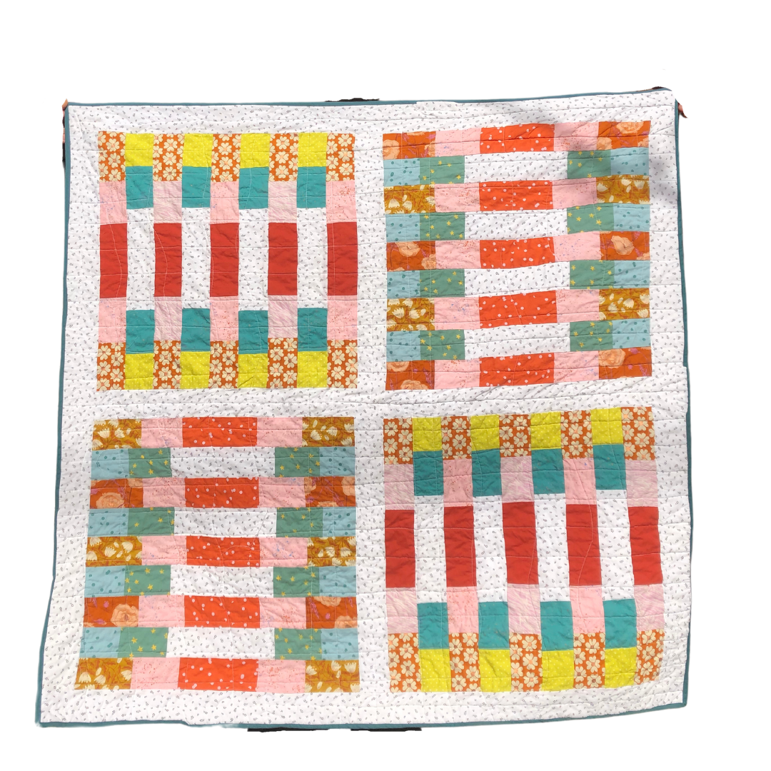 a colorful patchwork quilt with orange, pink, yellow, and blue squares