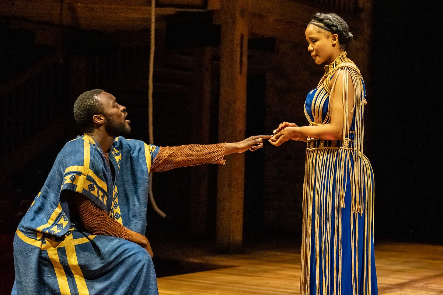 A photo of Pericles at the RSC with an actor in robes kneeling in front of a woman