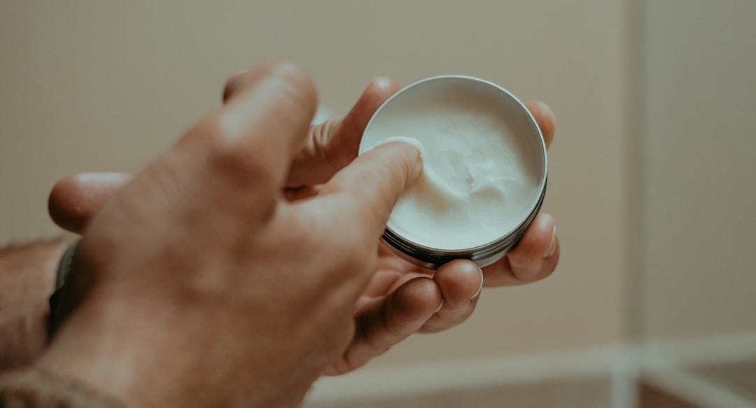 a person holding a bowl of cream in their hand