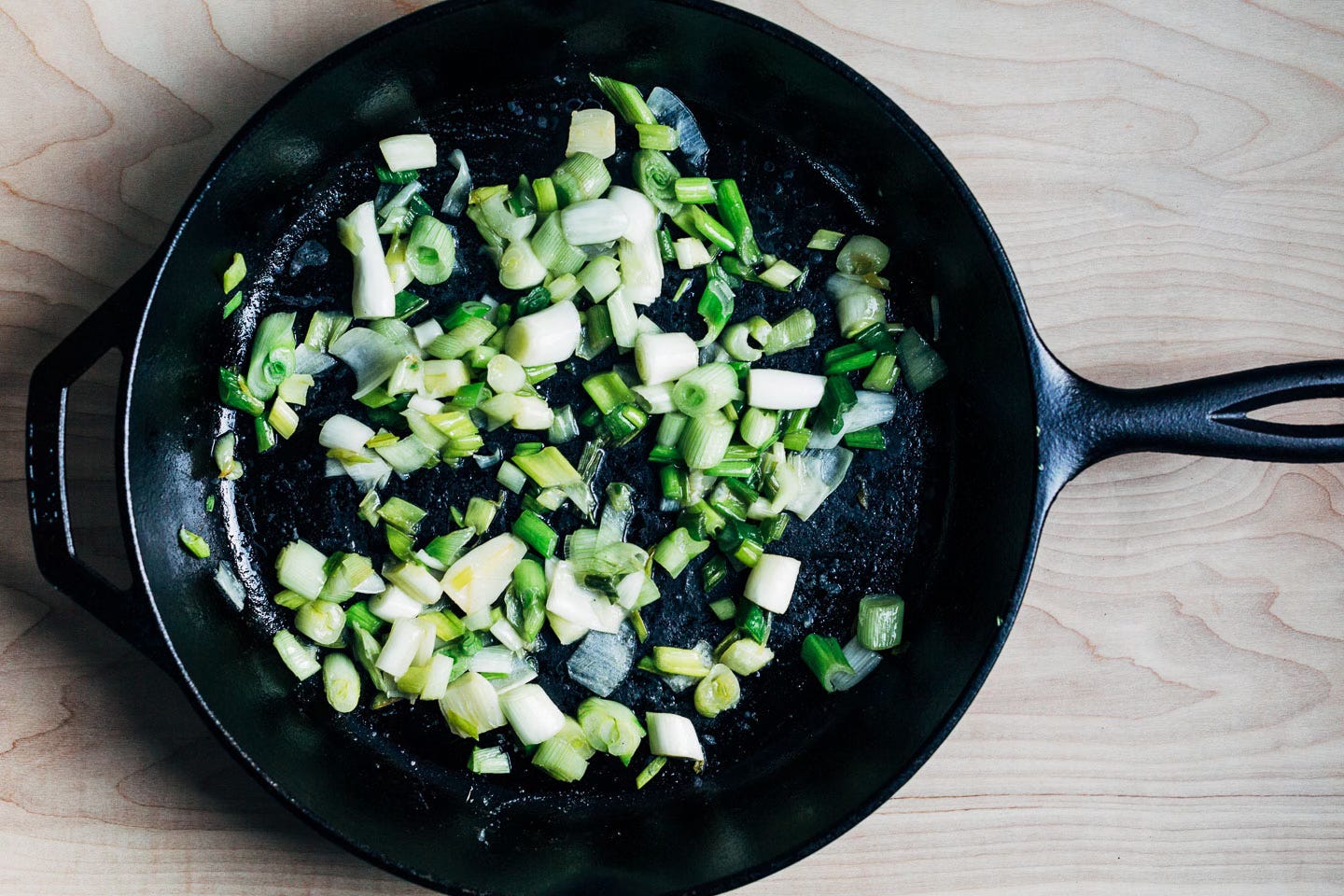A skillet with cooked spring onions