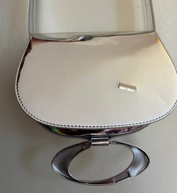 shiny silvr purse with broken clasp open