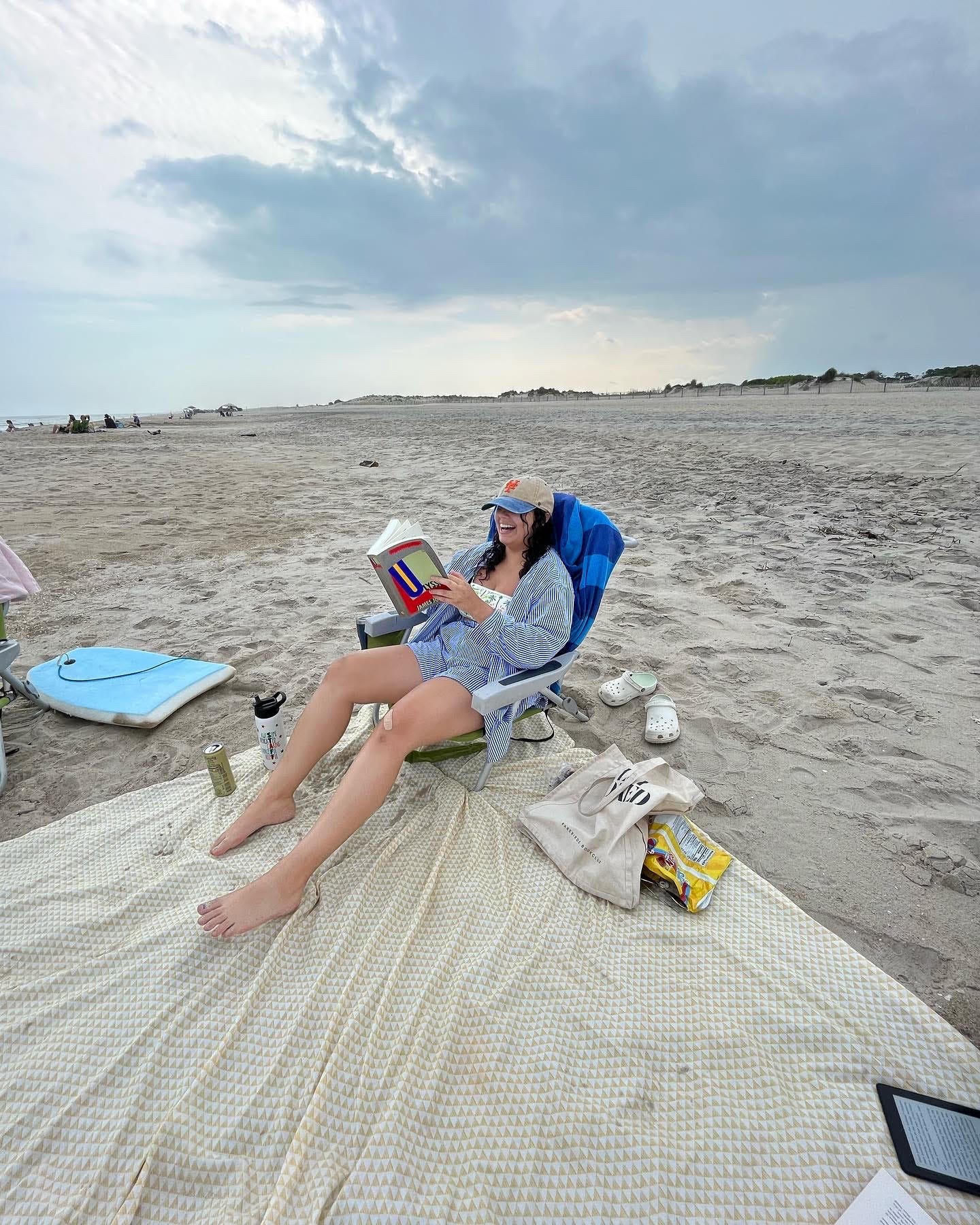me on a beach chair at the beach holding a copy of ulysses but clearly not reading it