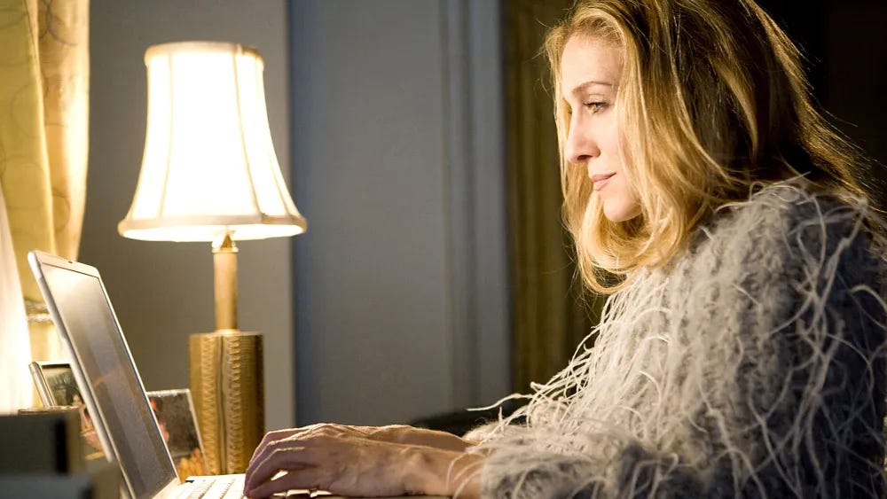Carrie Bradshaw sitting at her laptop