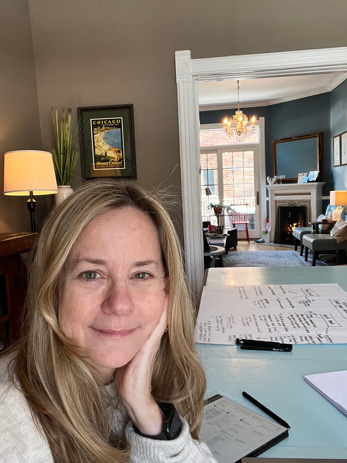 Memoir coach Christine Wolf at Writers' Haven Evanston, sitting at the dining room table and smiling at the camera.