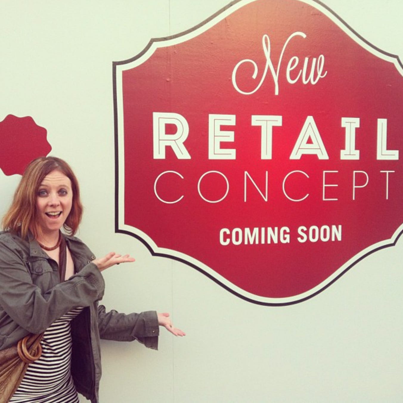 woman standing in front of a sign that says "new retail concept coming soon"