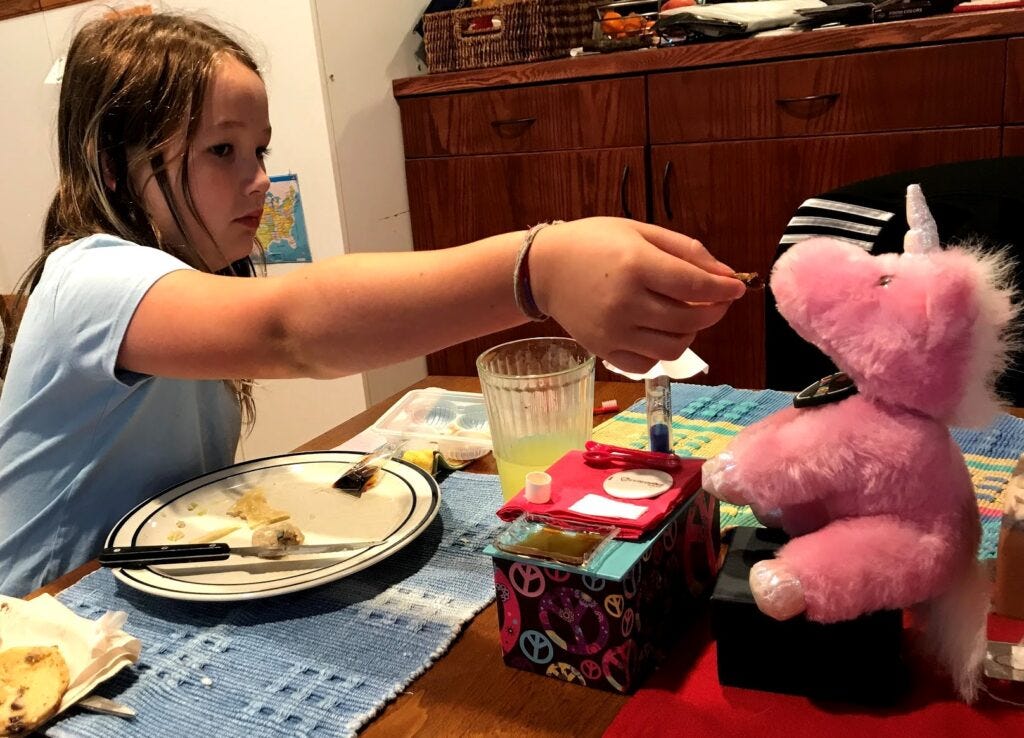 Etta feeding breakfast to her unicorn stuffy