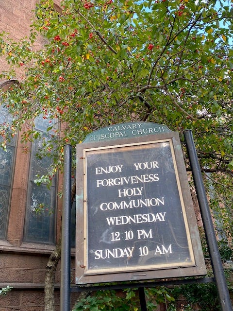 The Calvary sign, reading in large letters ENJOY YOUR FORGIVENESS. And also the times for communion.