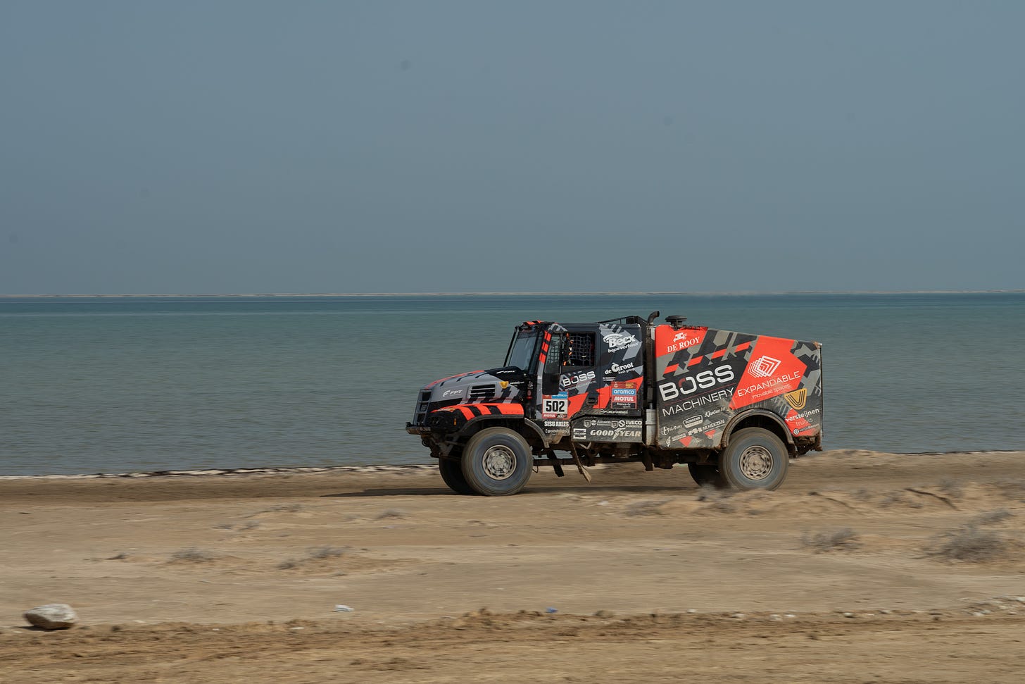 A 20,000-pound diesel truck racing across a beach strewn with plastic bottles.