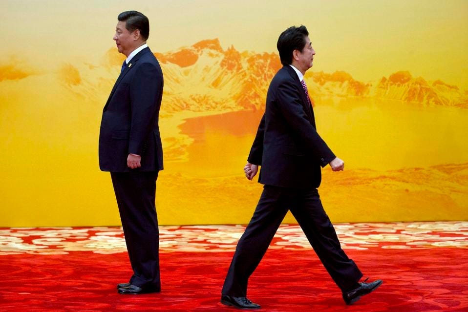In this Tuesday, Nov. 11, 2014 photo, Japan's Prime Minister Shinzo Abe, right, walks past Chinese... [+] President Xi Jinping during a welcome ceremony for the Asia-Pacific Economic Cooperation (APEC) summit at the International Convention Center in Yanqi Lake, Beijing, China. (AP Photo/Ng Han Guan)