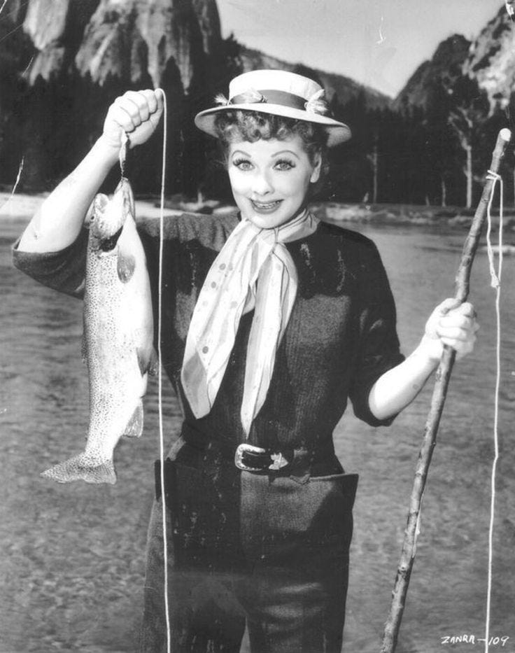 This may contain: an old black and white photo of a woman holding a fish on a fishing pole