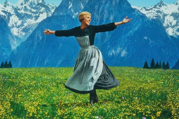 Photo of Julie Andrews dancing in a field in front of a mountain in the Sound of Music.