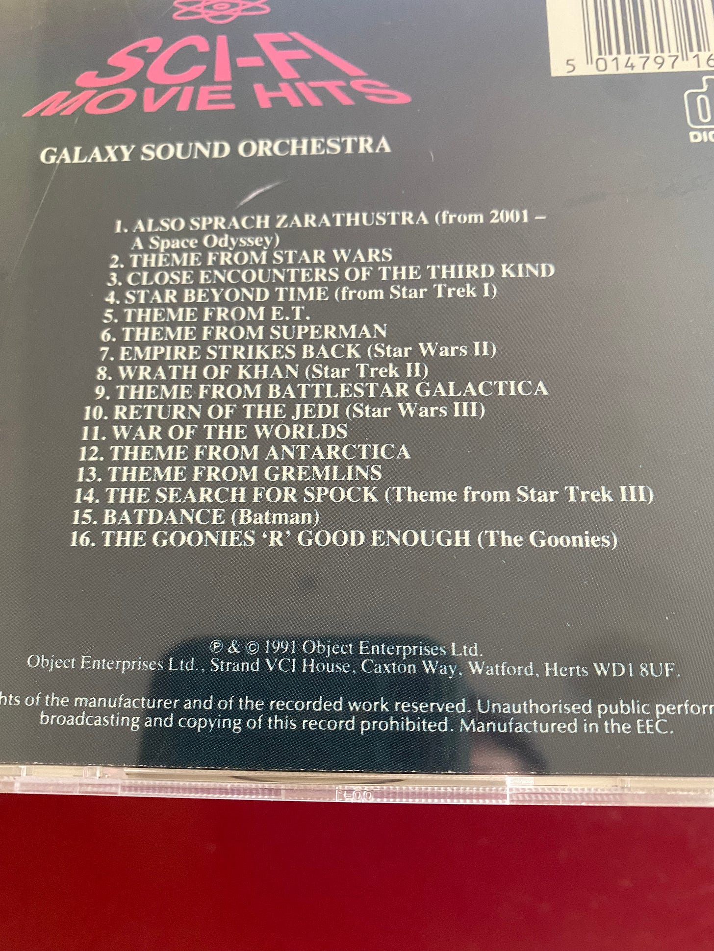 the back case of a CD entitled "Sci-Fi Movie Hits", performed by the Galaxy Sound Orchestra. It has 16 tracks ranging from Star Trek and 2001 to Star Wars to The Goonies.