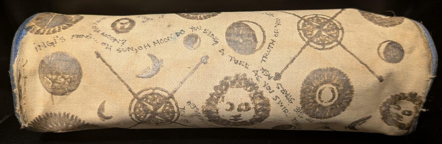A cylindrical canvas bag, with inked words weaving among the astronomy themed symbols A cylindrical canvas bag, with inked words weaving among the astronomy themed symbols