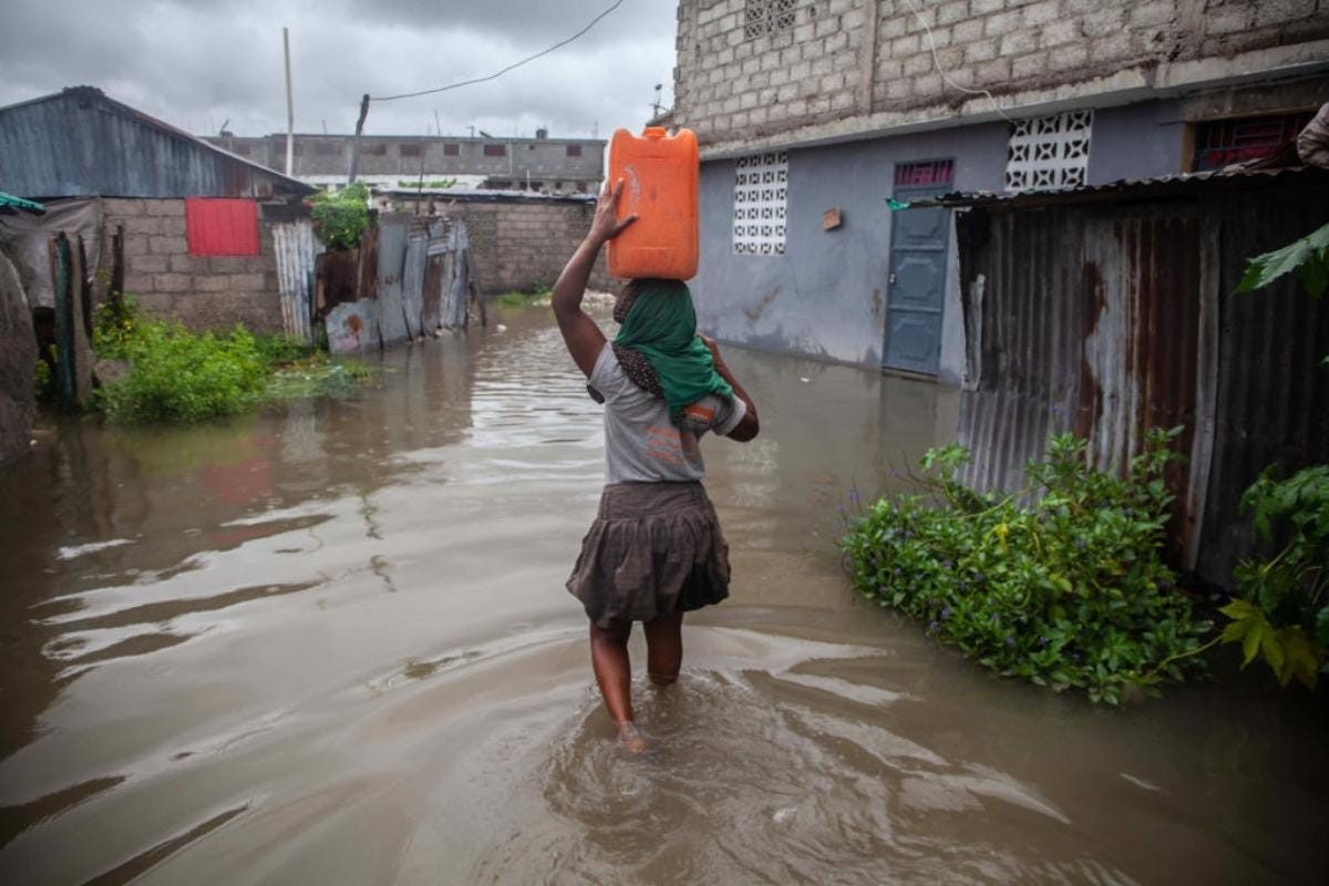 A Haitian woman makes her way through flooded areas after Tropical Storm Grace