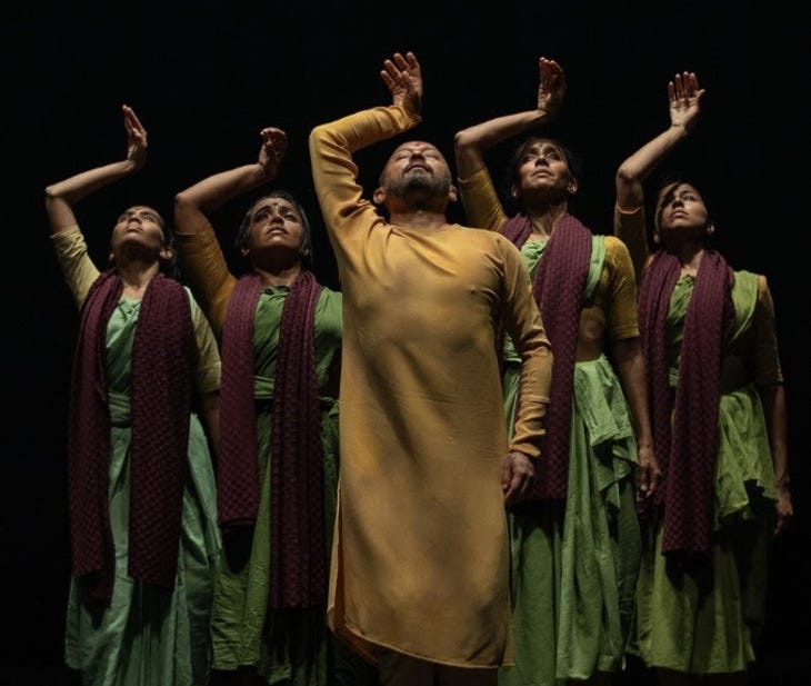 Five dancers performing an identical pose with their right hand lifted to their heads