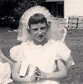 A young girl in a first communion dress and veil