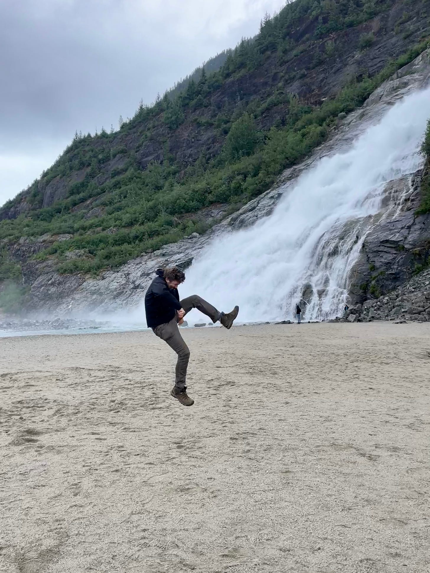 Garrett jumping and kicking in front of a waterfall