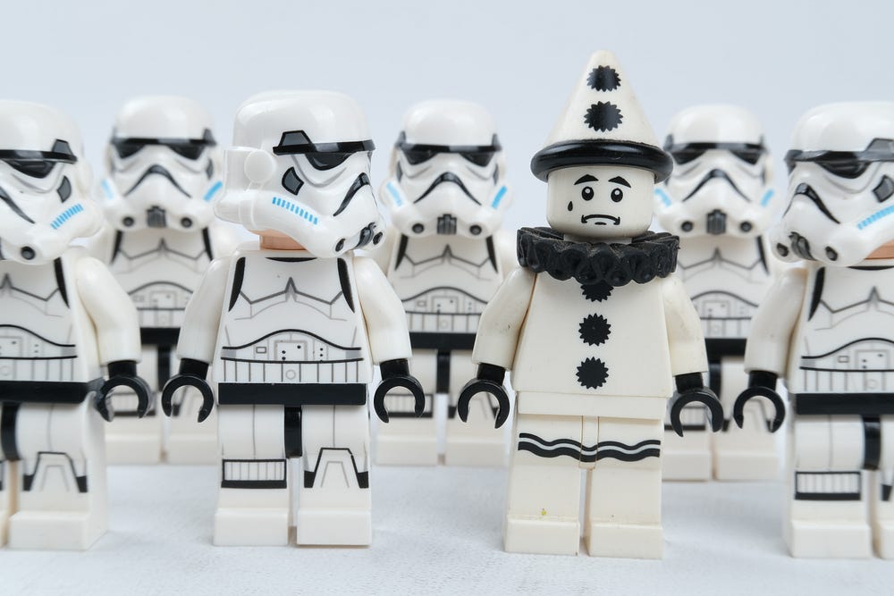 Picture of storm trooper lego pieces, where one of the storm troopers is a clown disguised as a storm trooper