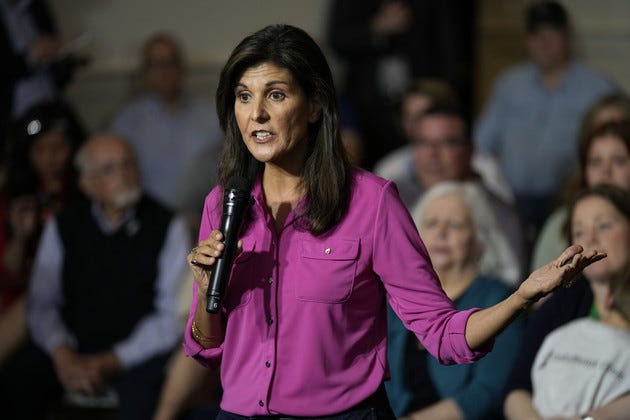 Nikki Haley speaks during a town hall campaign event with a crowd behind her. 