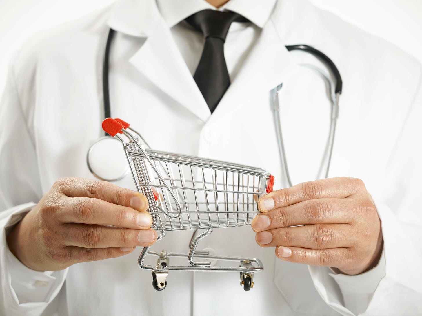 A doctor holds a small shopping cart.