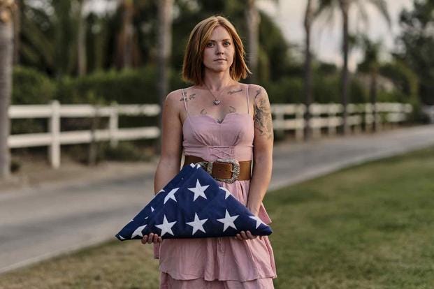 Katelyn Kleffman holds a folded flag outside her home in Perris, California