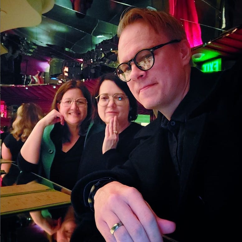 Image shows Lauren Cerand, Maud Newton, and Maximus Clarke at a bar in Baltimore