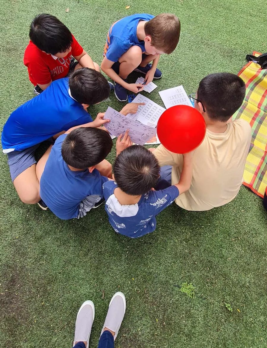 A group of kids sitting on the ground

Description automatically generated