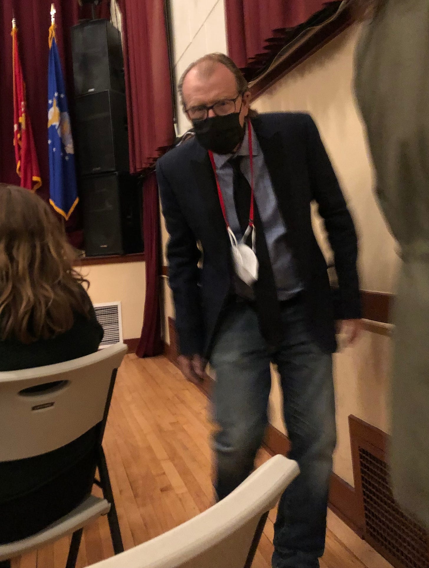 Author George Saunders wearing a mask and walking down the aisle of an auditorium