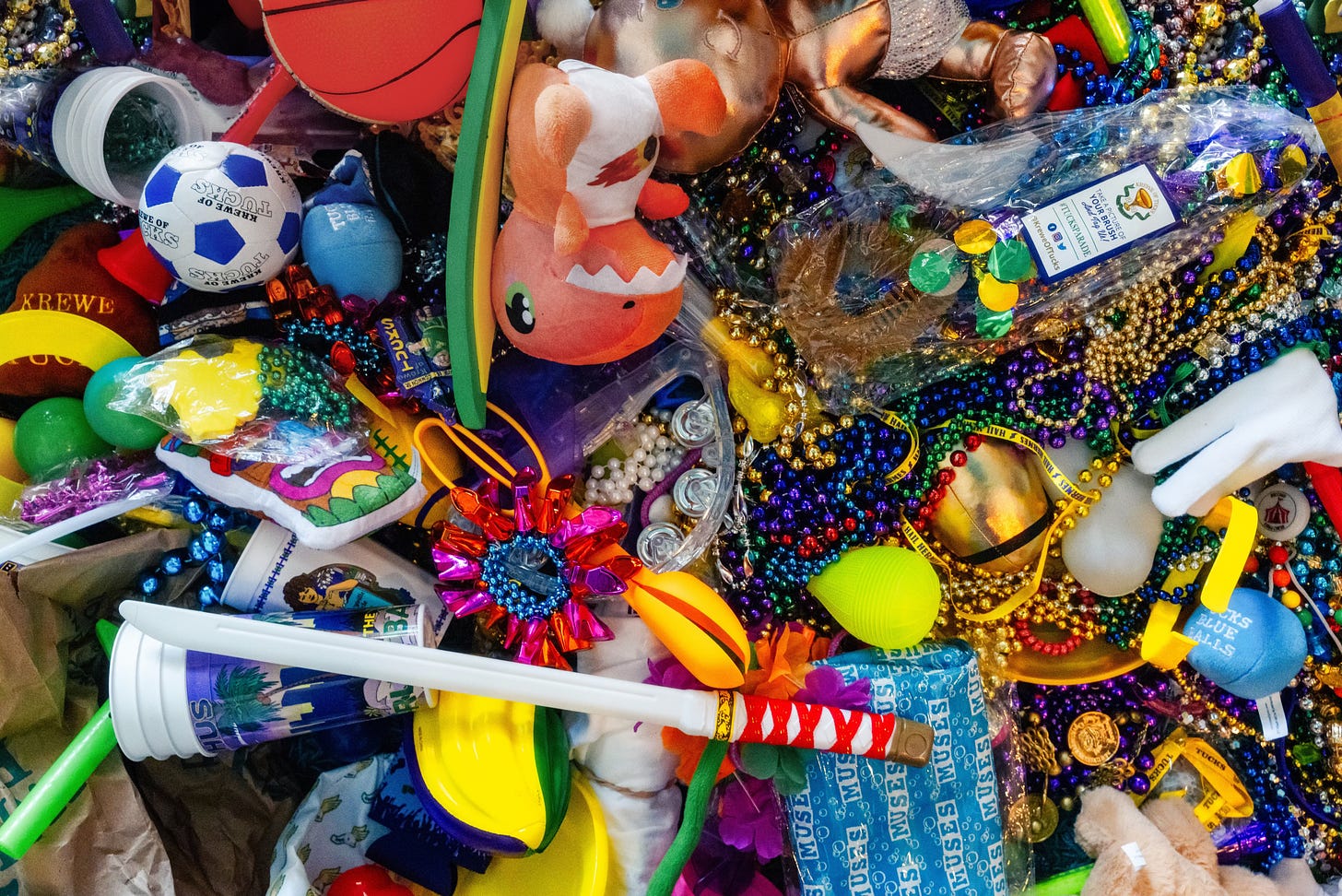 A colorful assortment of beads, stuffed toys, balls, cups, and plastic swords caught at Mardi Gras parades.