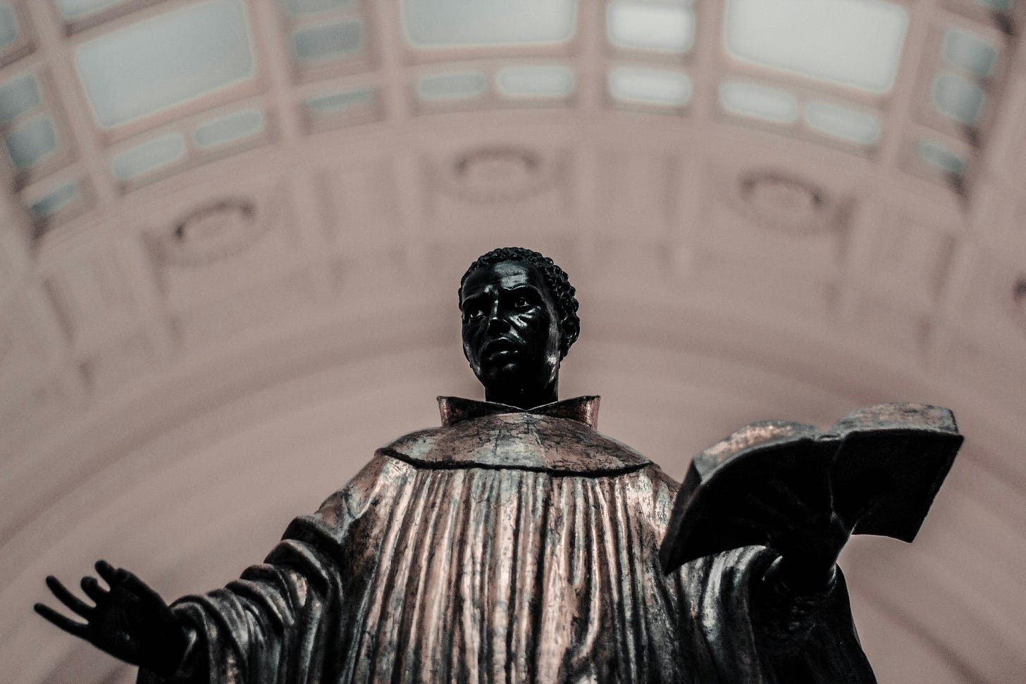 Statue of a man holding a book and pontificating 