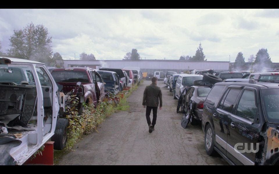 Dean Winchester walking up car scrap heap piles with Christian Kane Lee