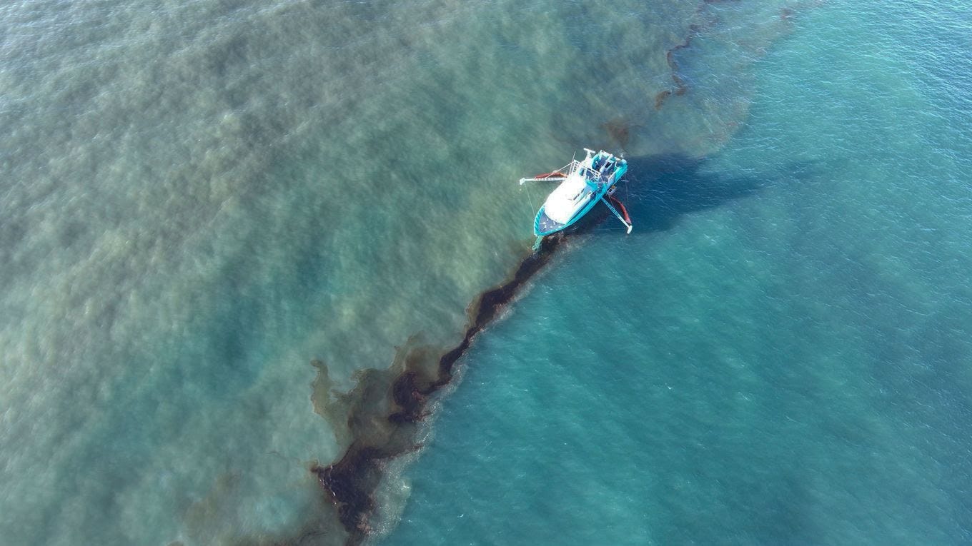 A response vessel skims crude oil last week. (U.S. Coast Guard/Clean Gulf Associates/AP)