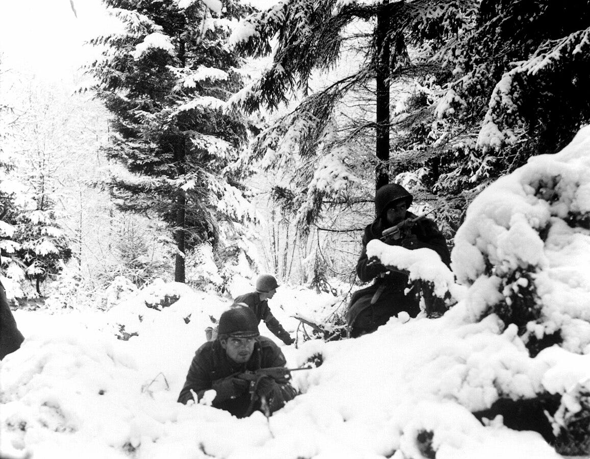American infantrymen of the 290th Regiment fight in fresh snowfall near Amonines, Belgium. January, 1945