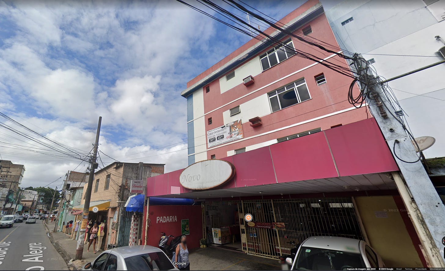 Um prédio de cor salmão e branco, acima de uma pandaria, a visão é de uma rua levemente movimentada retirada do Google Maps