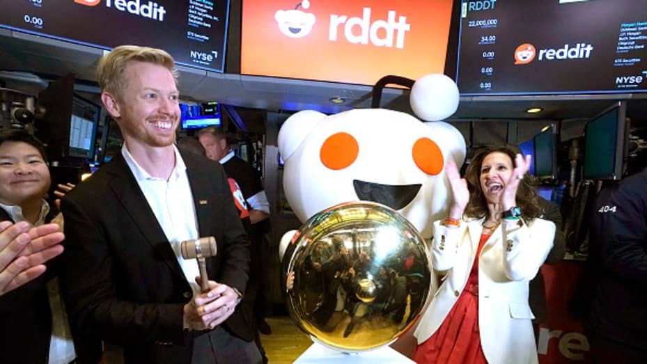Reddit CEO Steve Huffman and New York Stock Exchange (NYSE) president Lynn Martin ring the opening bell during the bell-ringing ceremony as Reddit begins trading on the New York Stock Exchange (NYSE) in New York on March 21, 2024.