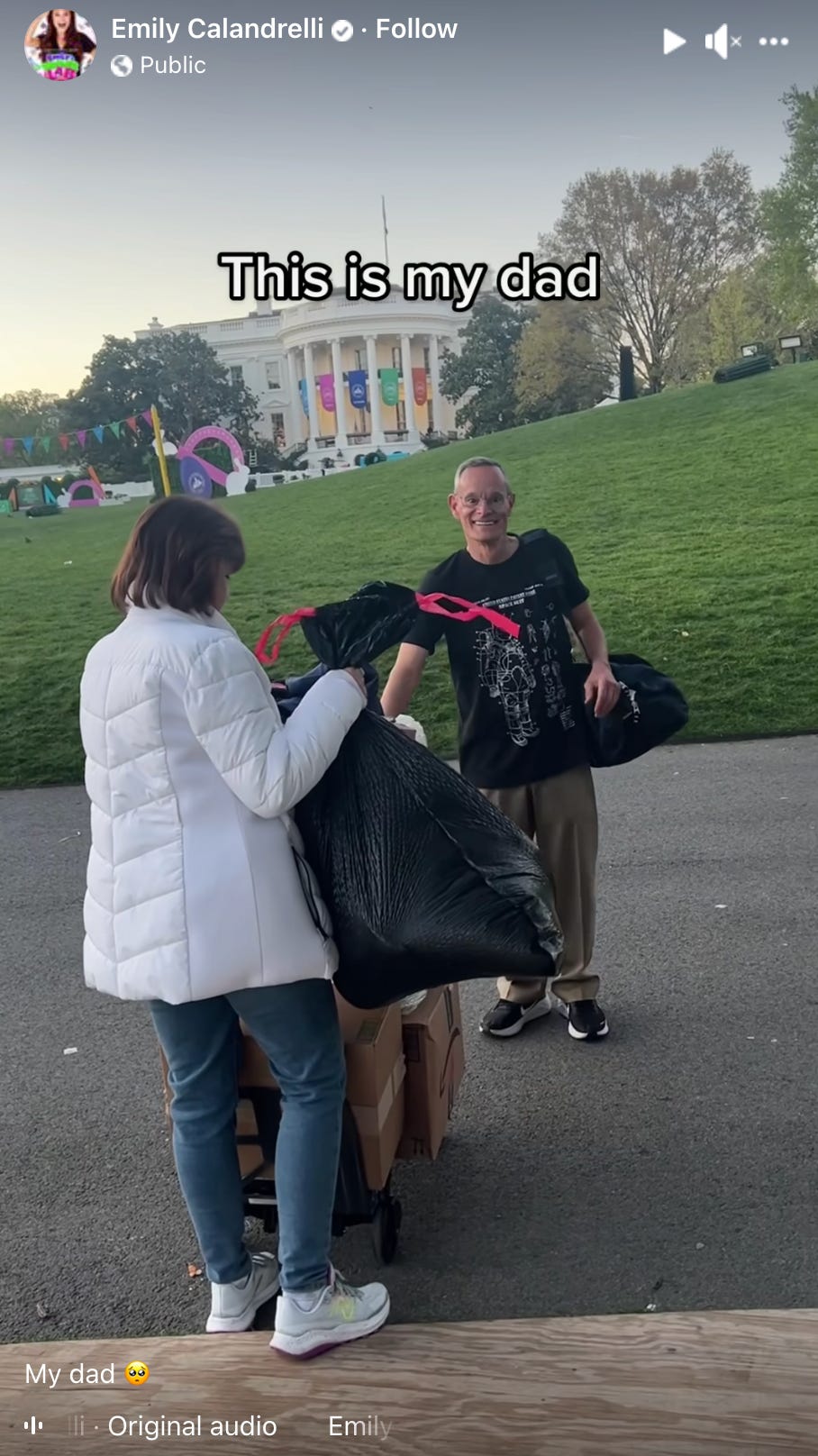 Screengrab of a father and daughter holding bags and boxes