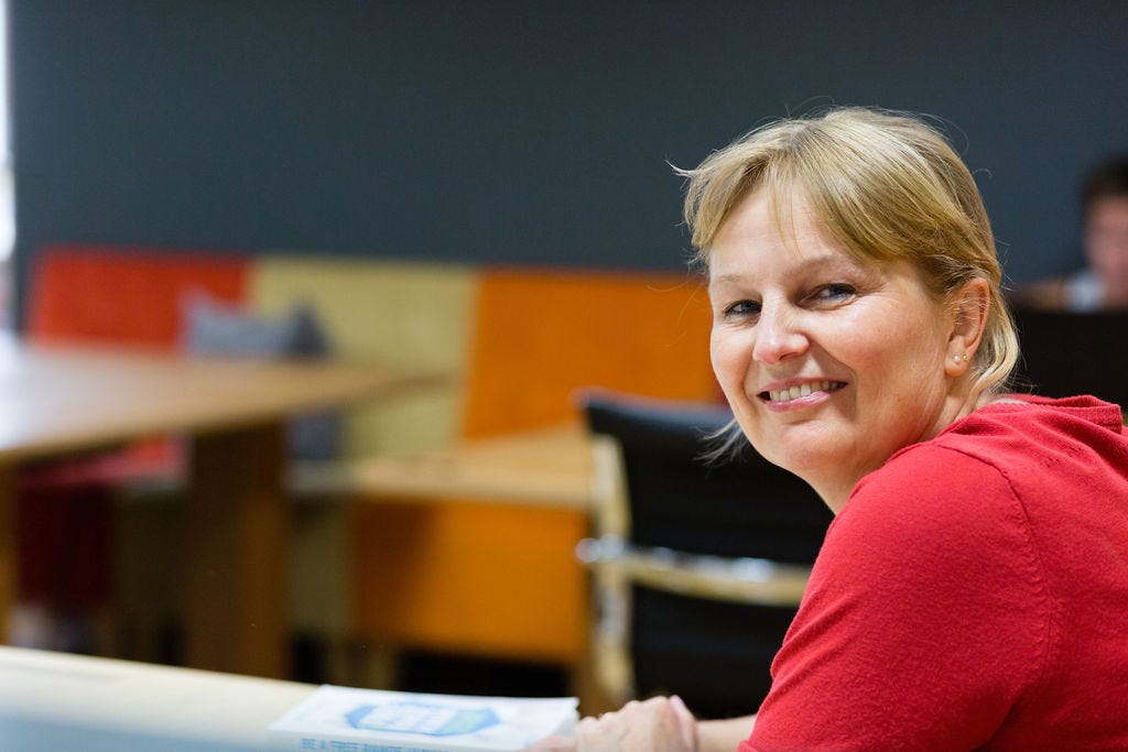 Tineke Tammes in red cardigan smiling in the camera