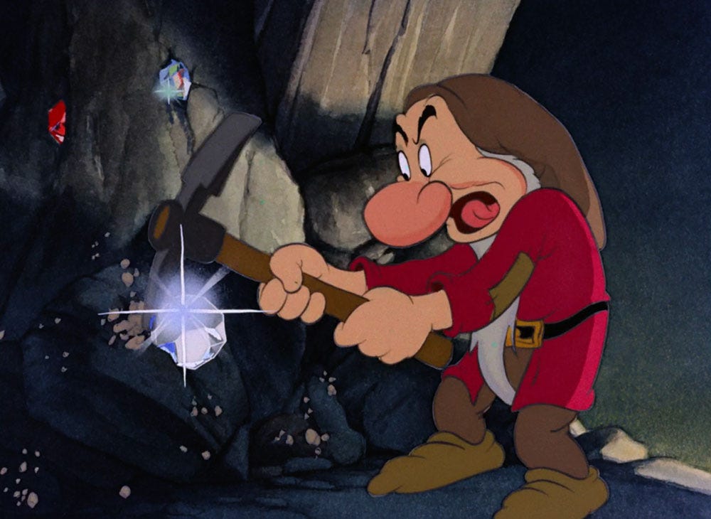 Grumpy the dwarf works in the diamond mine, using a pick to free a huge, glinting diamond from the rock - a still from 1937 animated film Snow White