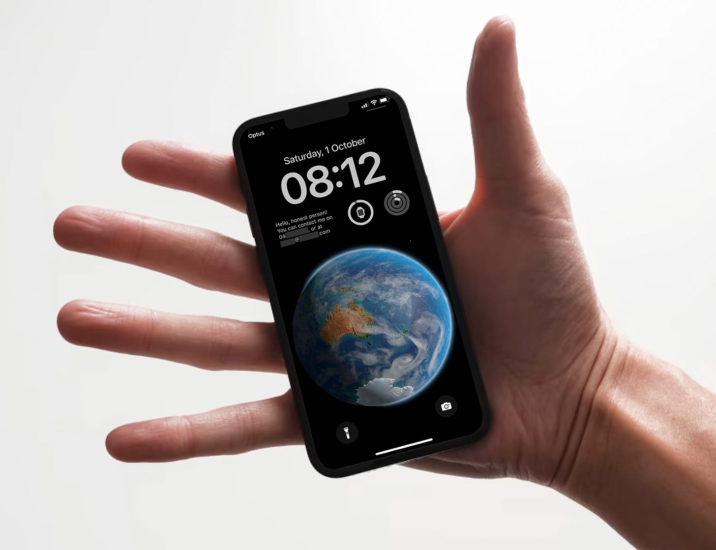 Open hand with black iPhone, showing the lock screen