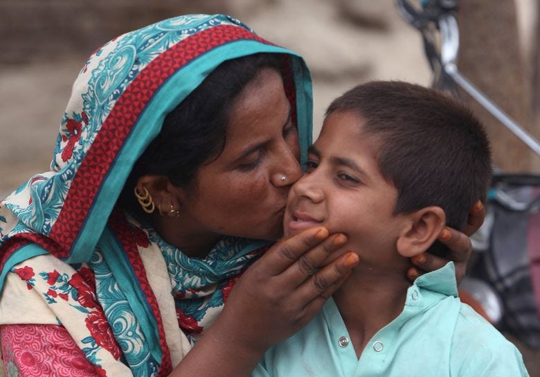 A Pakistani mother kisses her son Ali Raza, 10, infected with HIV in a village near Ratodero, a small town in southern province of Sindh in Pakistan, Thursday, May 16, 2019. Officials say about 500 people, mostly children, have tested positive for HIV, the virus that causes AIDS, in a southern Pakistani provincial district. A local doctor who has AIDS has since been arrested and is being investigated for possibly intentionally infecting patients. (AP Photo/Fareed Khan)