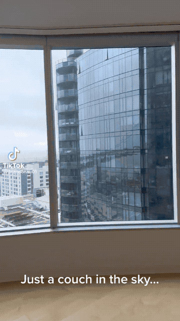 Palindrome gif of a futon flying past an upper-floor skyscraper window in San Francisco.