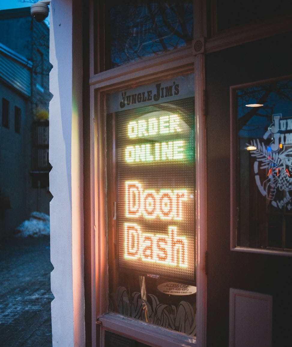 brown wooden door with red and yellow neon sign