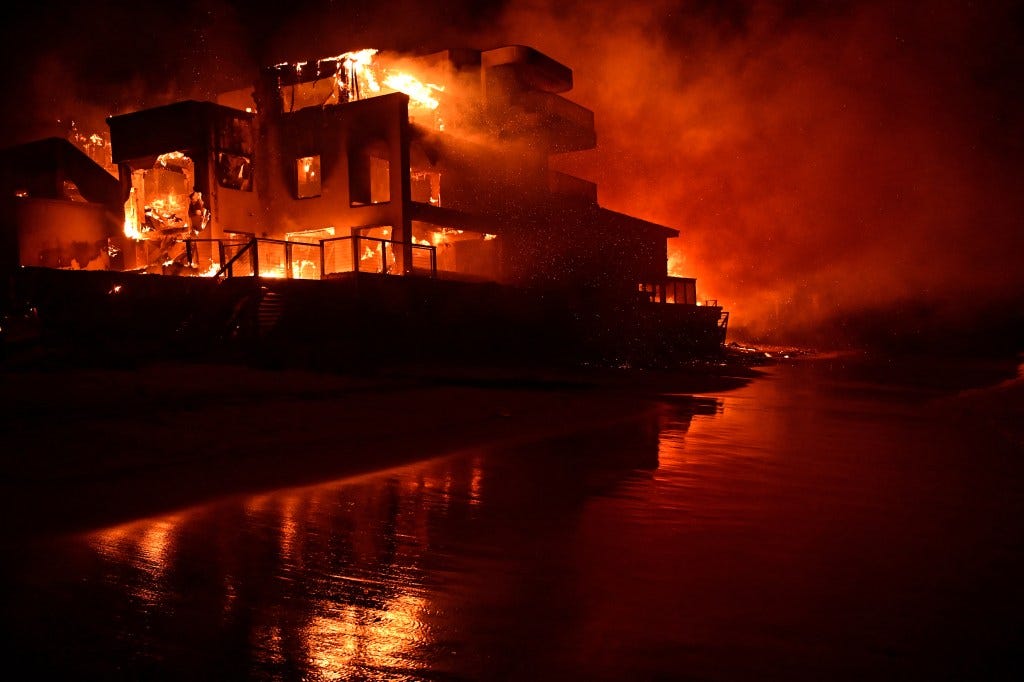 A beach house in Malibu, California, engulfed in flames during the Palisades Fire at night on January 8, 2025