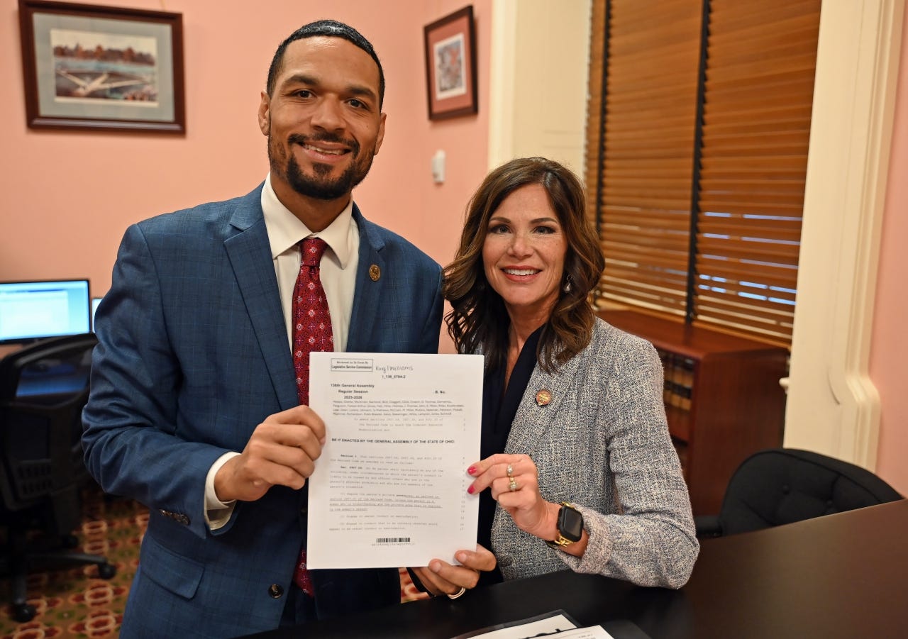 Representatives Josh Williams and Angie King hold up a paper version of their bill. Representatives Josh Williams and Angie King hold up a paper version of their bill.